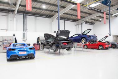 Ferrari cars in repair workshop parked on smooth and seamless floor