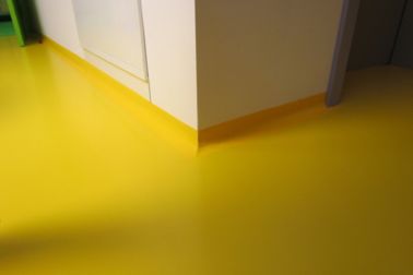 Seamless coving transition detail at floor to wall connection in yellow floor