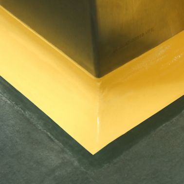 Yellow floor to wall coving detail at seamless joint between wall and floor with Sikagard