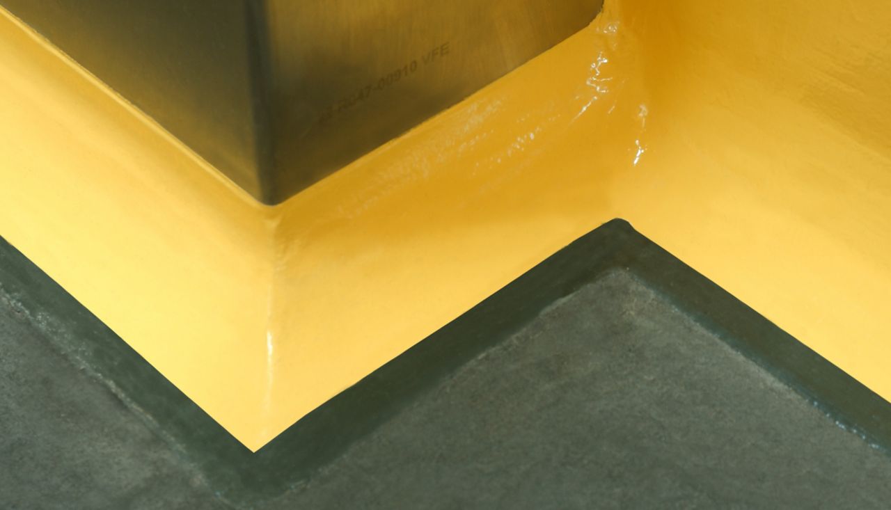 Yellow floor to wall coving detail at seamless joint between wall and floor with Sikagard