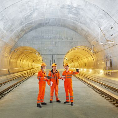 Three construction workers talking inside Gotthard Tunnel in Switzerland