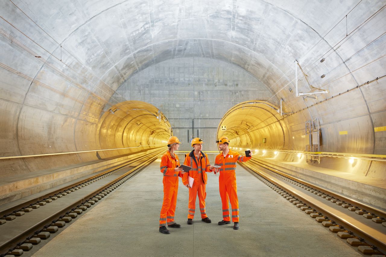 Three construction workers talking inside Gotthard Tunnel in Switzerland