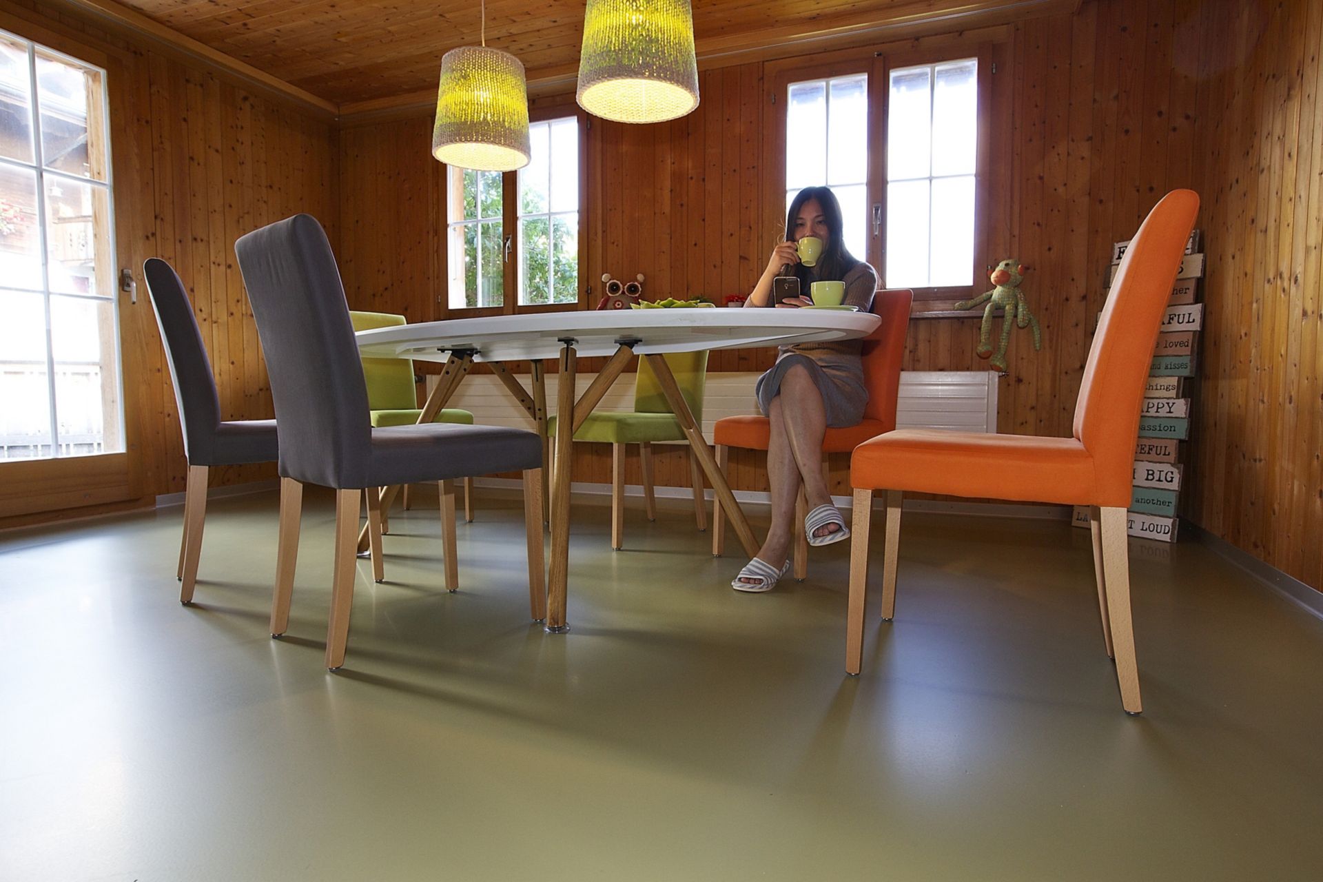 Sika ComfortFloor® green floor with lady drinking tea at dining room table