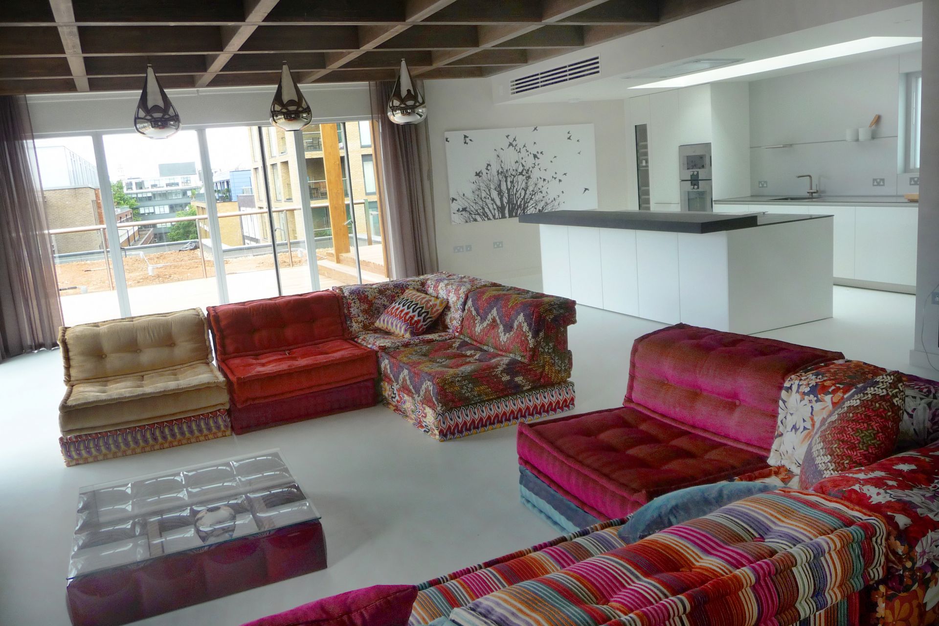 Sika ComfortFloor® grey floor in living room kitchen with red pattern sofa