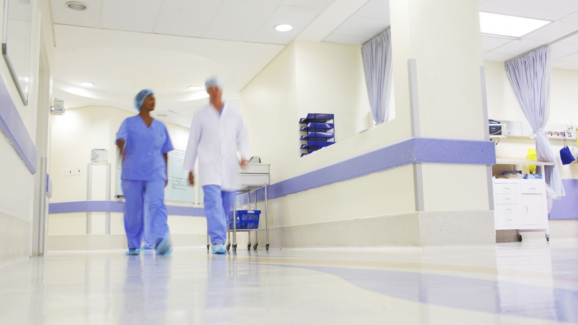 Doctor and nurse walking through hospital with wall and floor coatings