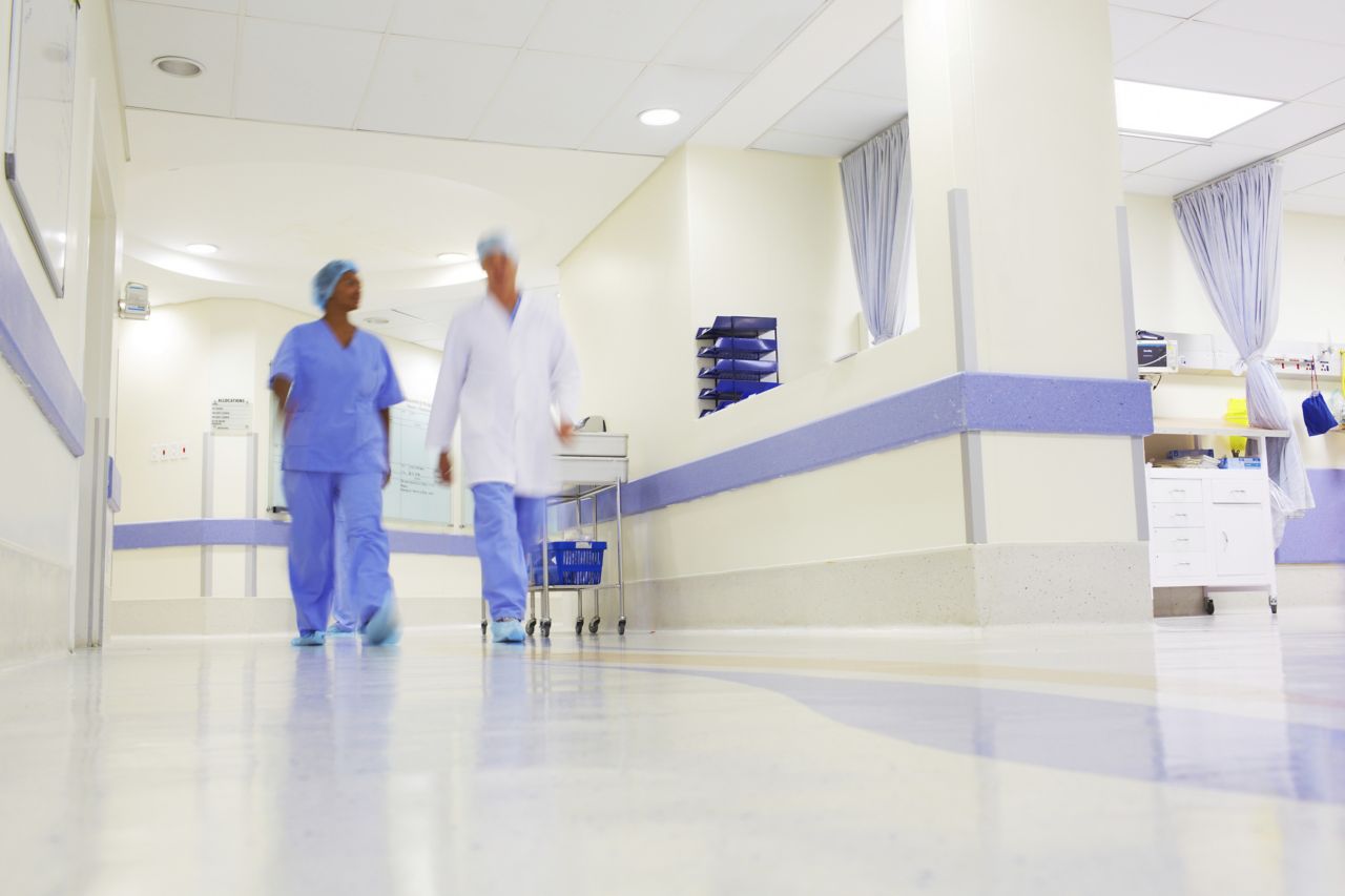 Doctor and nurse walking through hospital with wall and floor coatings