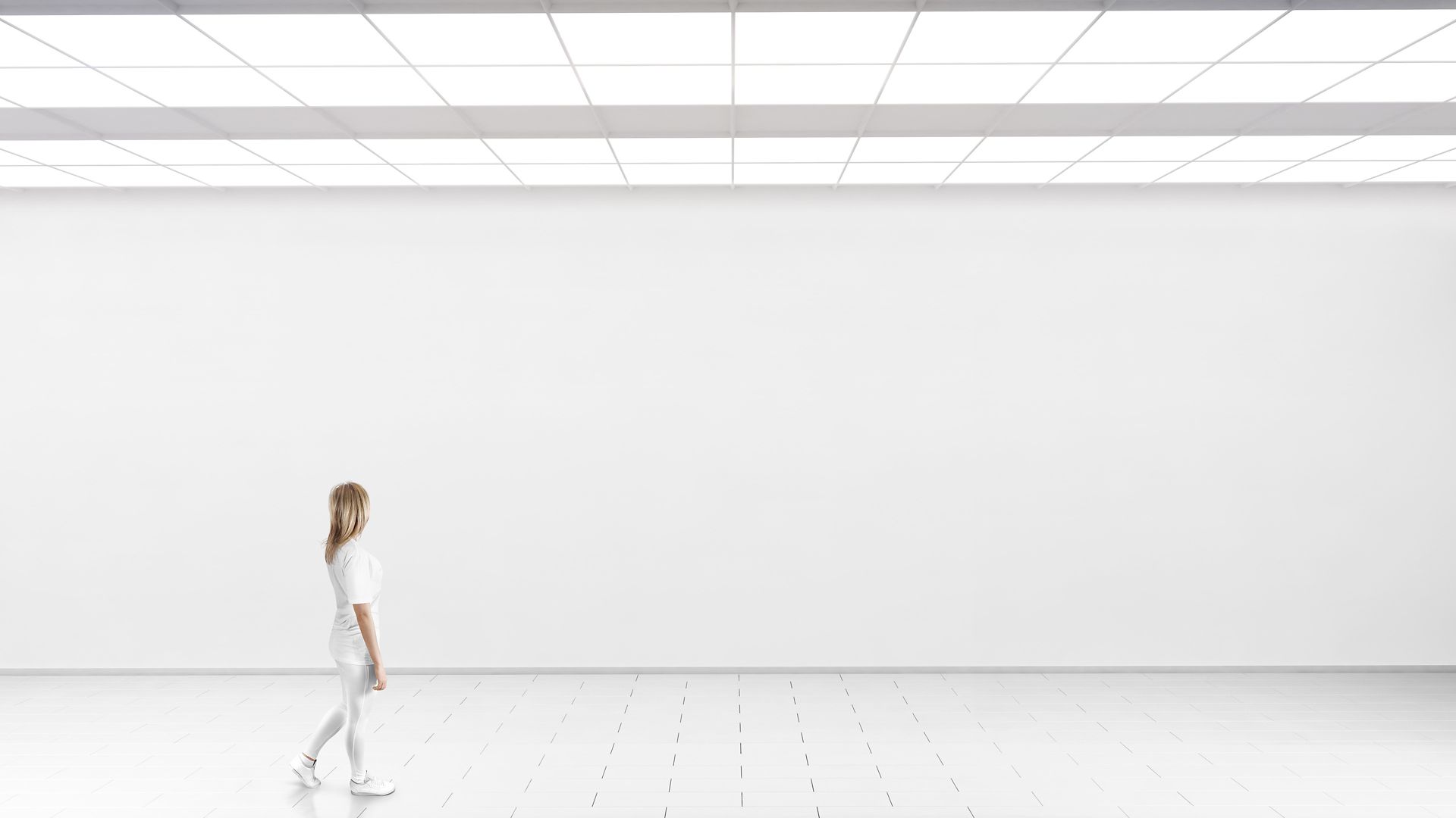 Woman walking in front of a white wall