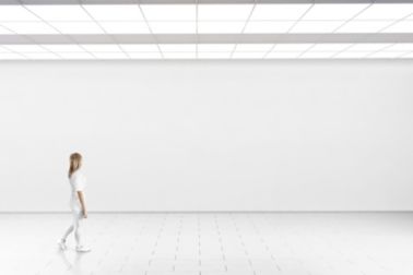 Woman walking in front of a white wall