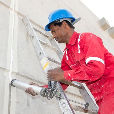 Man sealing joints of Musanda Villa structure with Sikaflex Construction+ at very high temperatures