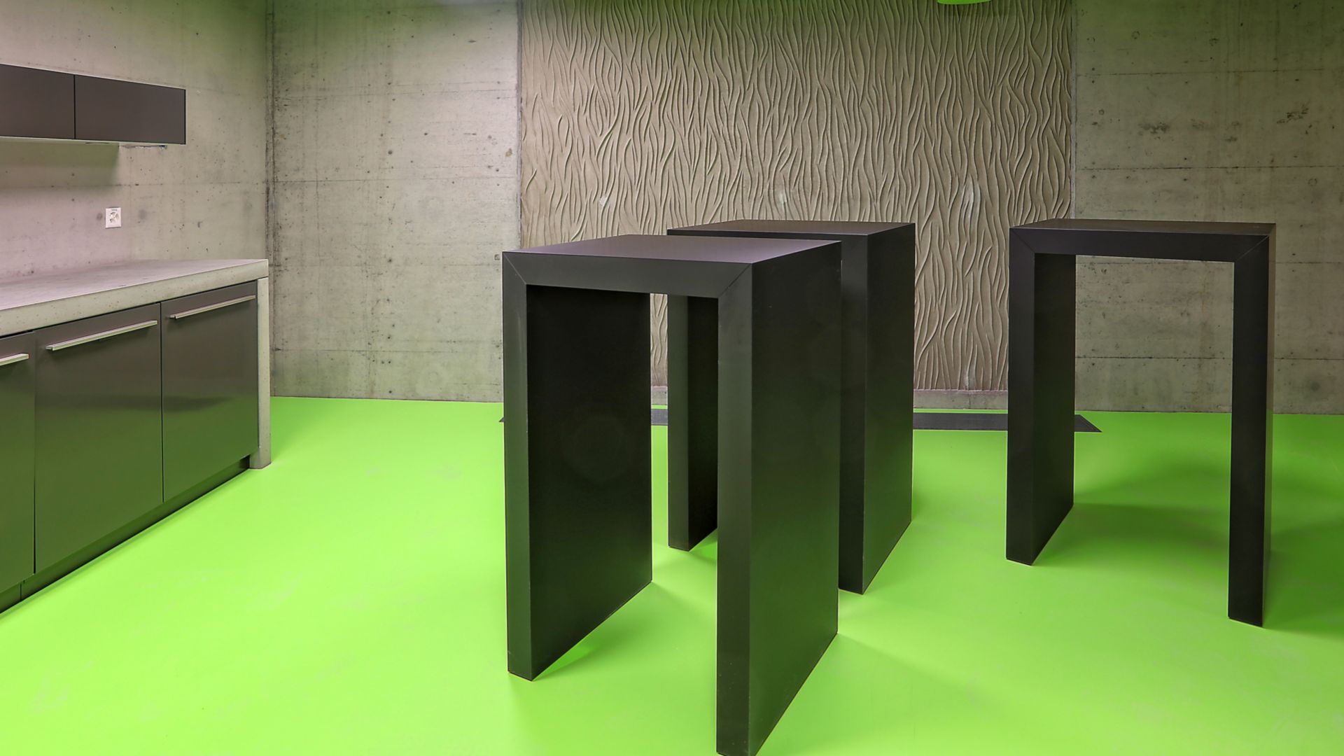 Green floor and architectural concrete wall in a kitchen