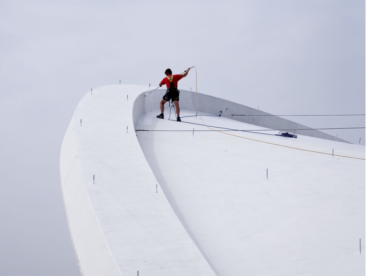 Construction worker applying Sikalastic liquid applied membrane on Congress Hall roof in Berlin Germany