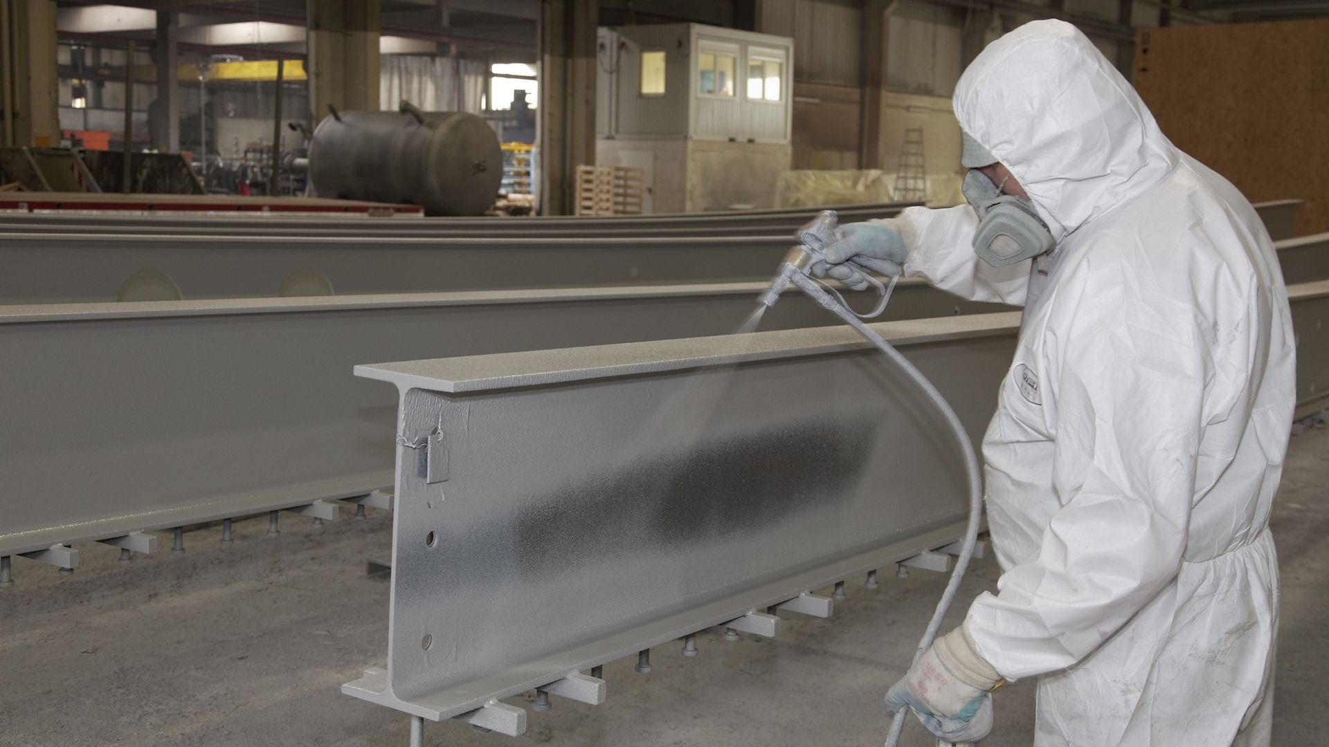   Man Applying Fire Resistant Coating on a  load-bearing structure	 