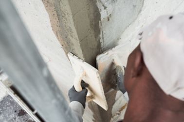 Man repairing concrete wall with Sika repair mortar