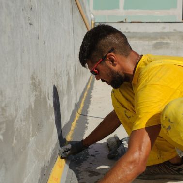 Man waterproofing at the Epirus Sport and Health Center in Ioannina, Greece