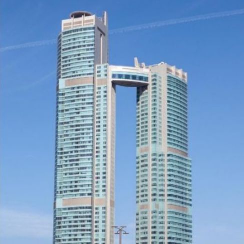 High-rise building with glass facade connected with a sky bridge