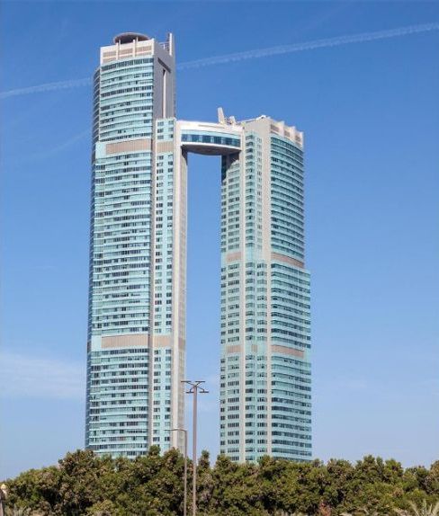High-rise building with glass facade connected with a sky bridge