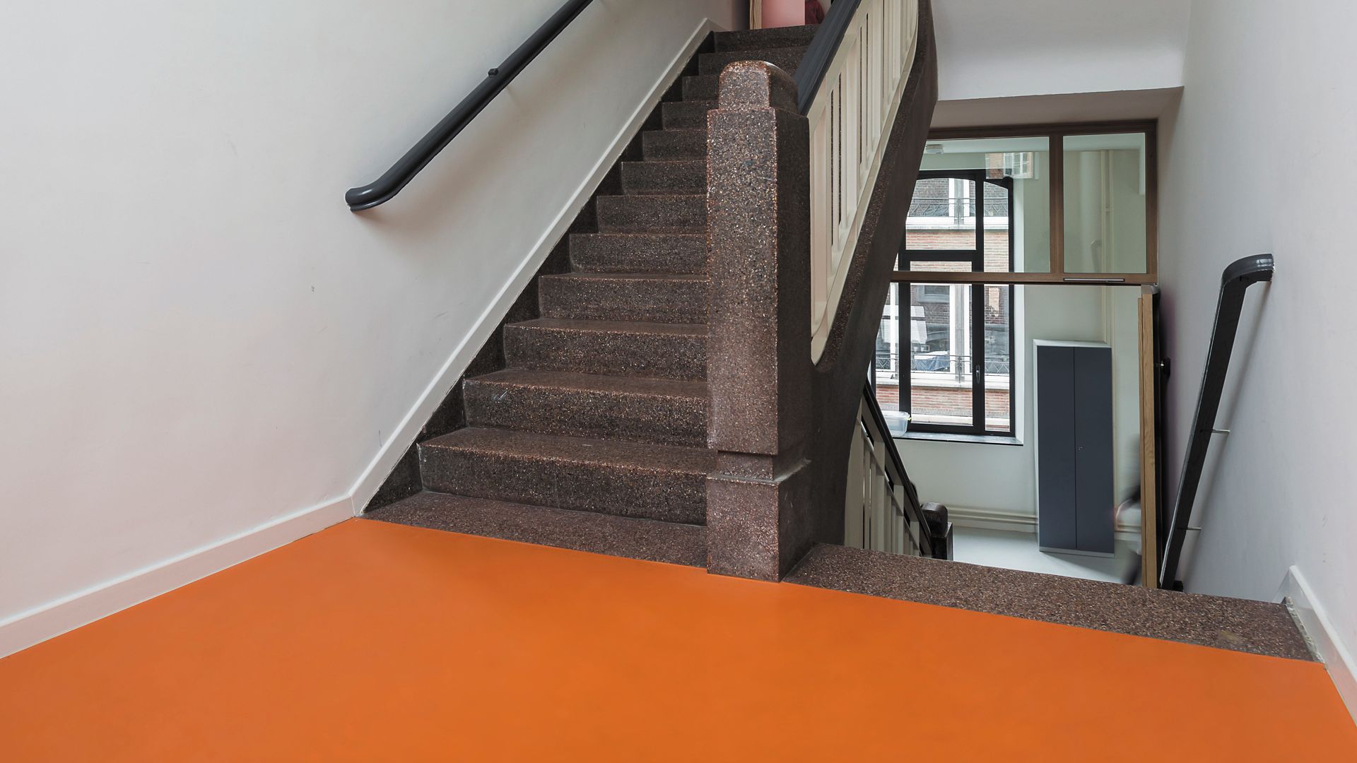 Sika ComfortFloor® orange floor at stair case at Notre Dame Namur school