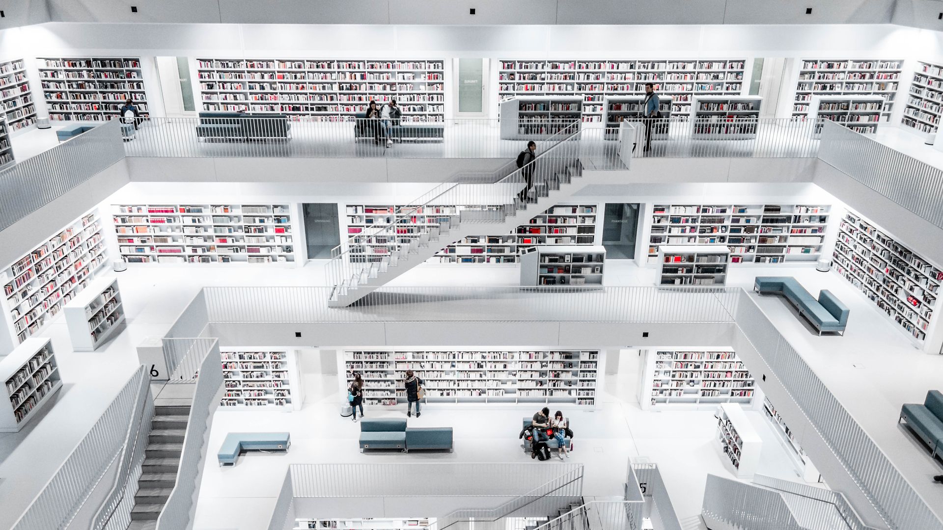 人们浏览现代图书馆，照片由Christian Wiediger在Unsplash上拍摄