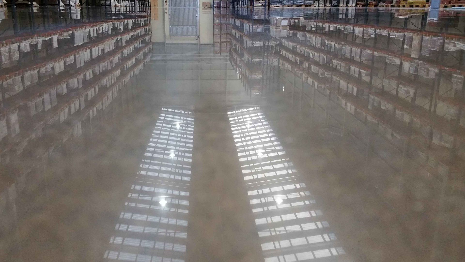 Polished concrete floor with dry shake hardener in storage warehouse using Sika SynTop Concria