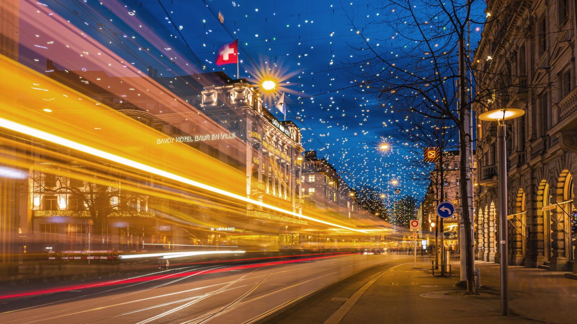 Rail fixing tram moving fast through Bahnhofstrasse street at night in Zurich, Switzerland