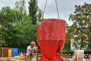 倾吐在大厦地下室的建筑工人准备好混合混凝土