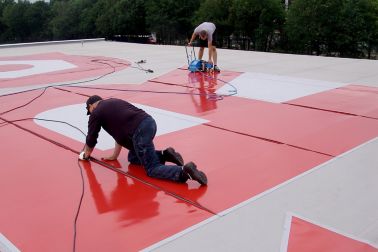 男子焊接红色彩色西卡屋顶图表到屋顶上