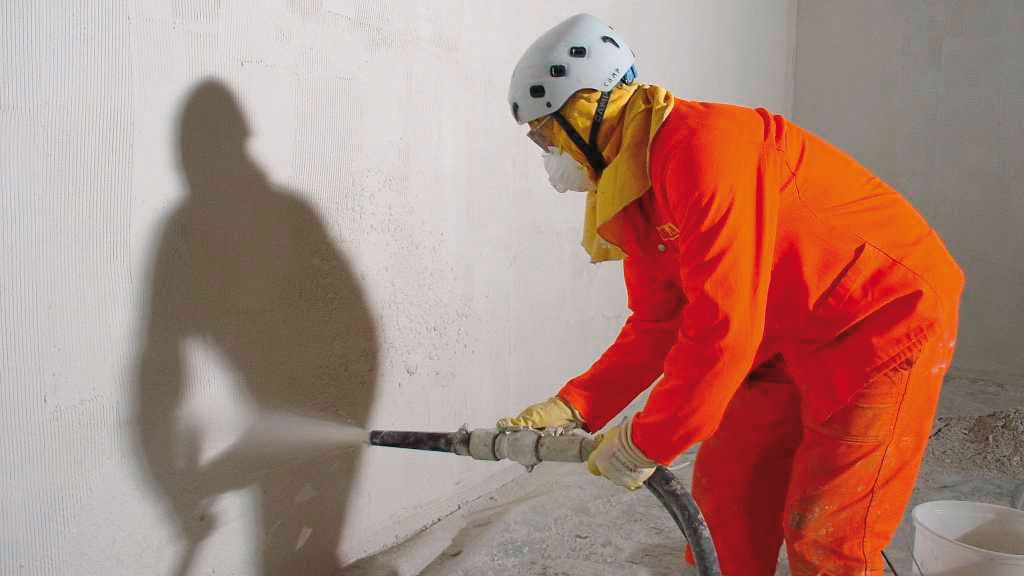   Man spraying mortar on the wall