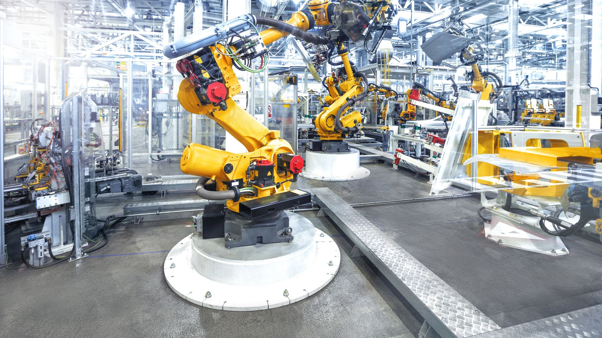Robotic arms in a car plant manufacturing warehouse