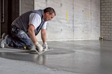 Man applying SikaScreed on floor