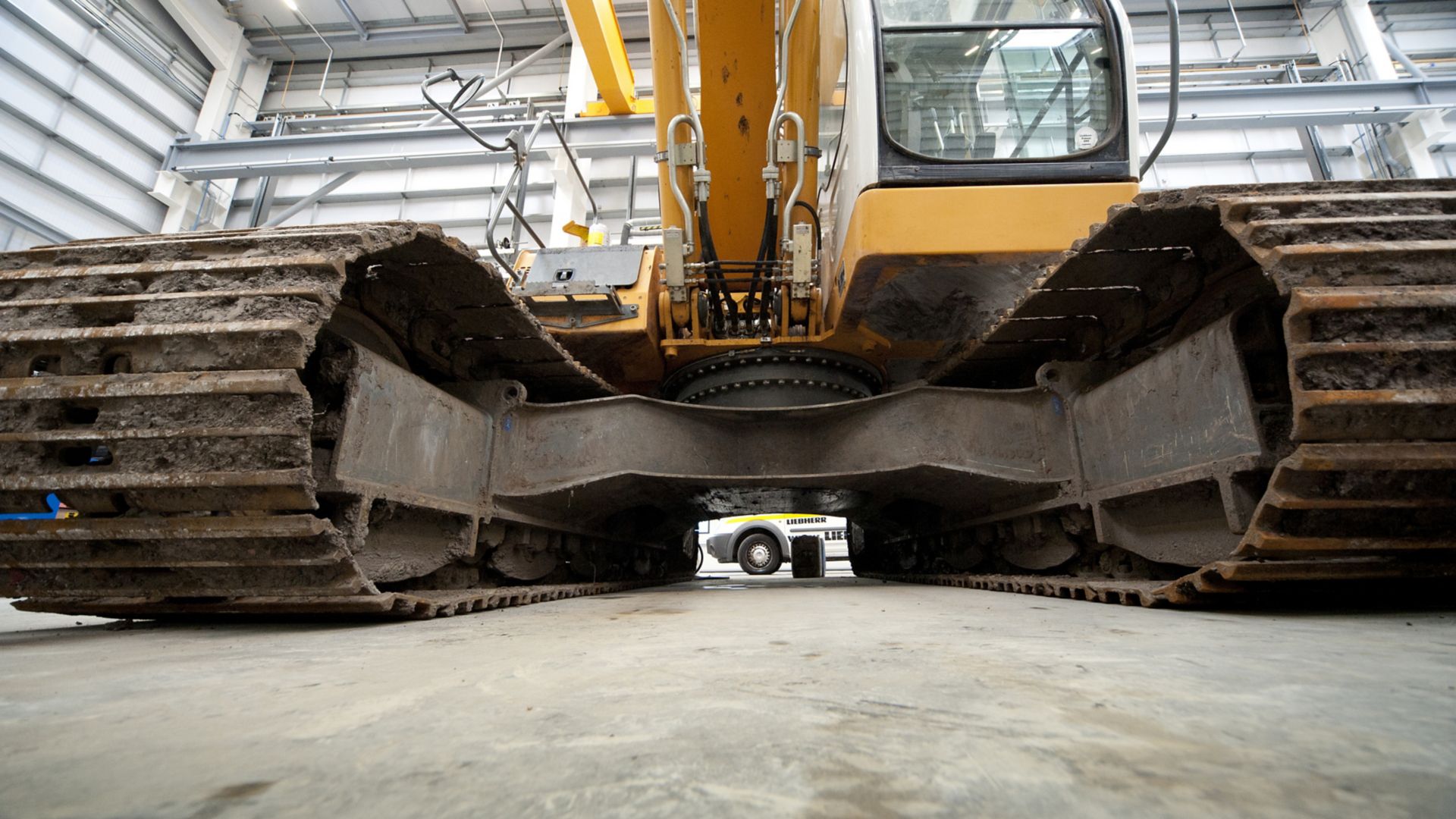 Excavator standing on heavy duty cementitious floor in warehouse