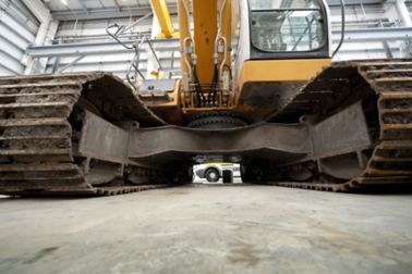 Excavator standing on heavy duty cementitious floor in warehouse