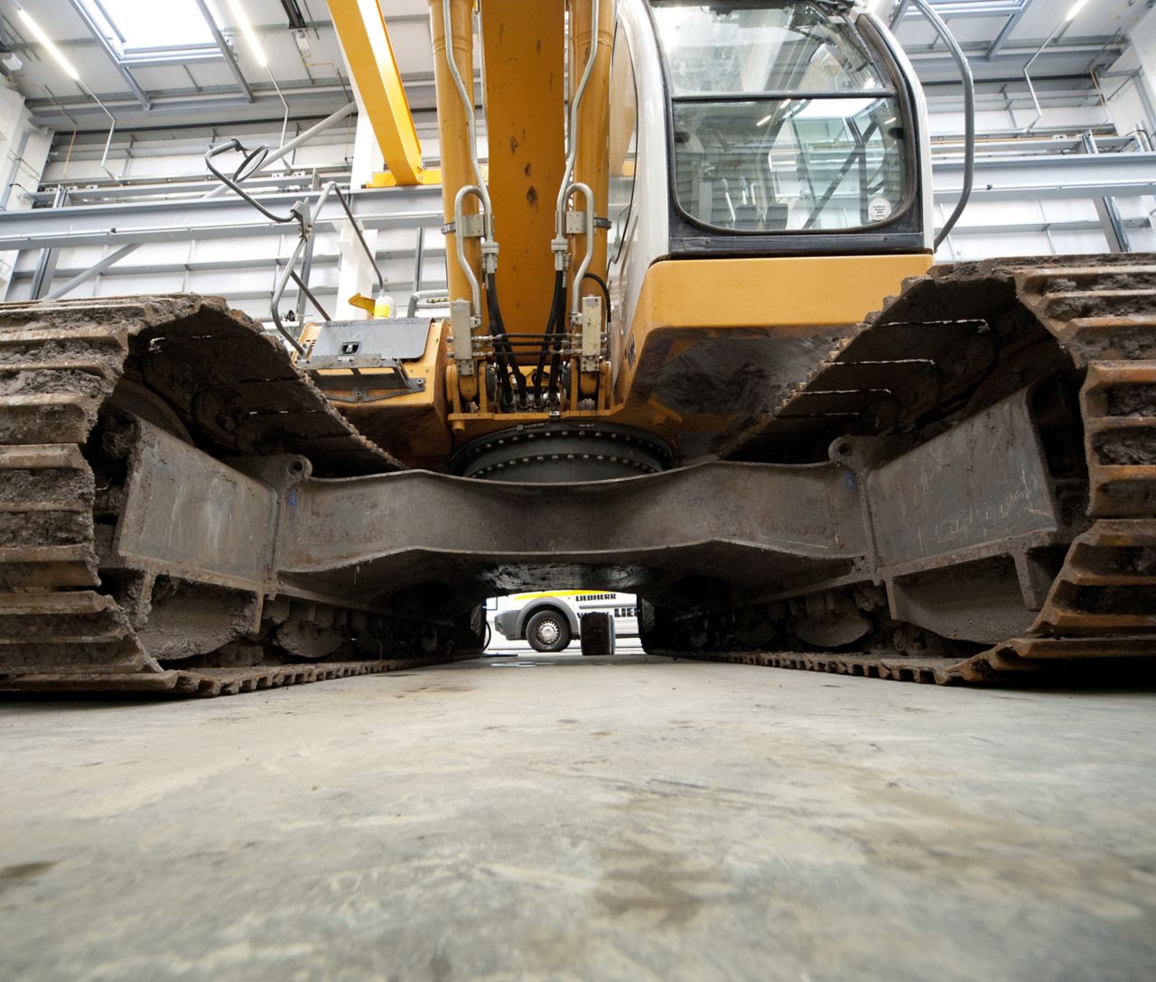 Excavator standing on heavy duty cementitious floor in warehouse