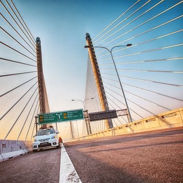 在第二个槟榔岛桥梁的白色汽车在马来西亚