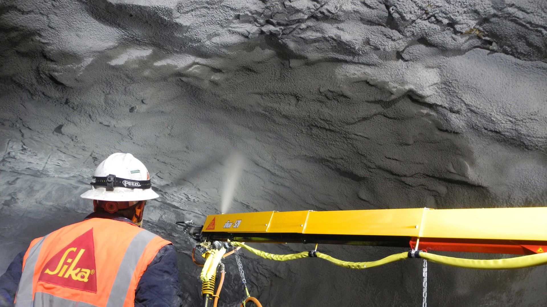 Sika engineer supervising concrete spraying in mine tunnel with Aliva shotcrete machine