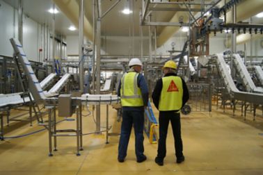 Sika man and owner food beverage factory standing talking side by side with Sika yellow floor Sikafloor® PurCem®