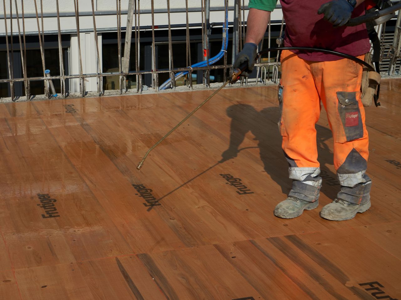              Man spraying Sika® Separol® formwork release agent on wood on construction site                  