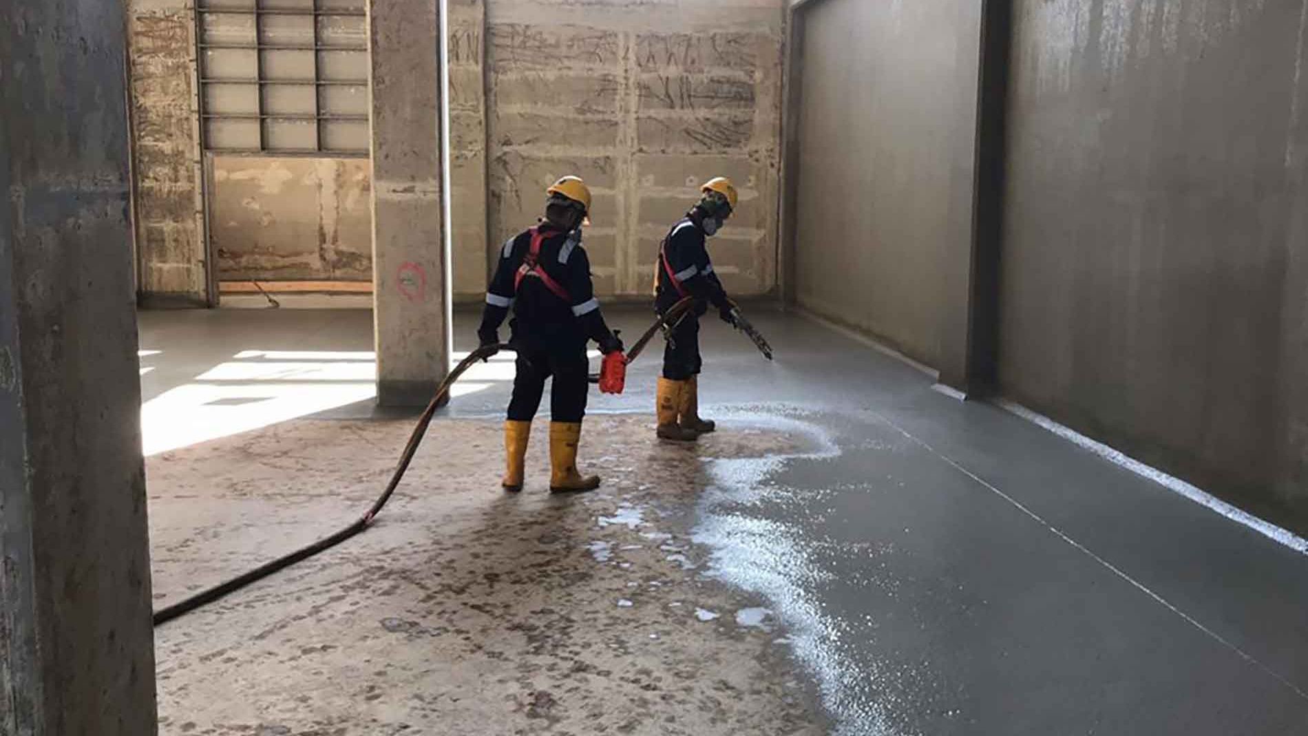 Sika Sikalastic spray applied waterproofing for water tank construction with workers