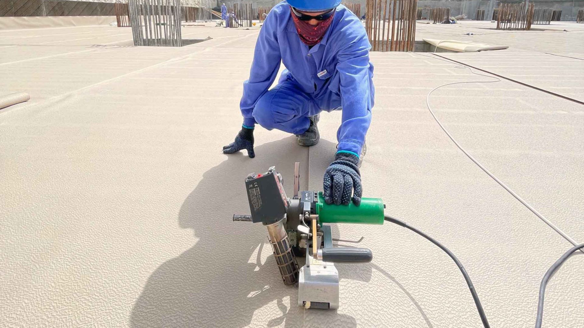 Worker applying SikaProof® A+ basement waterproofing membrane at construction site in Qatar