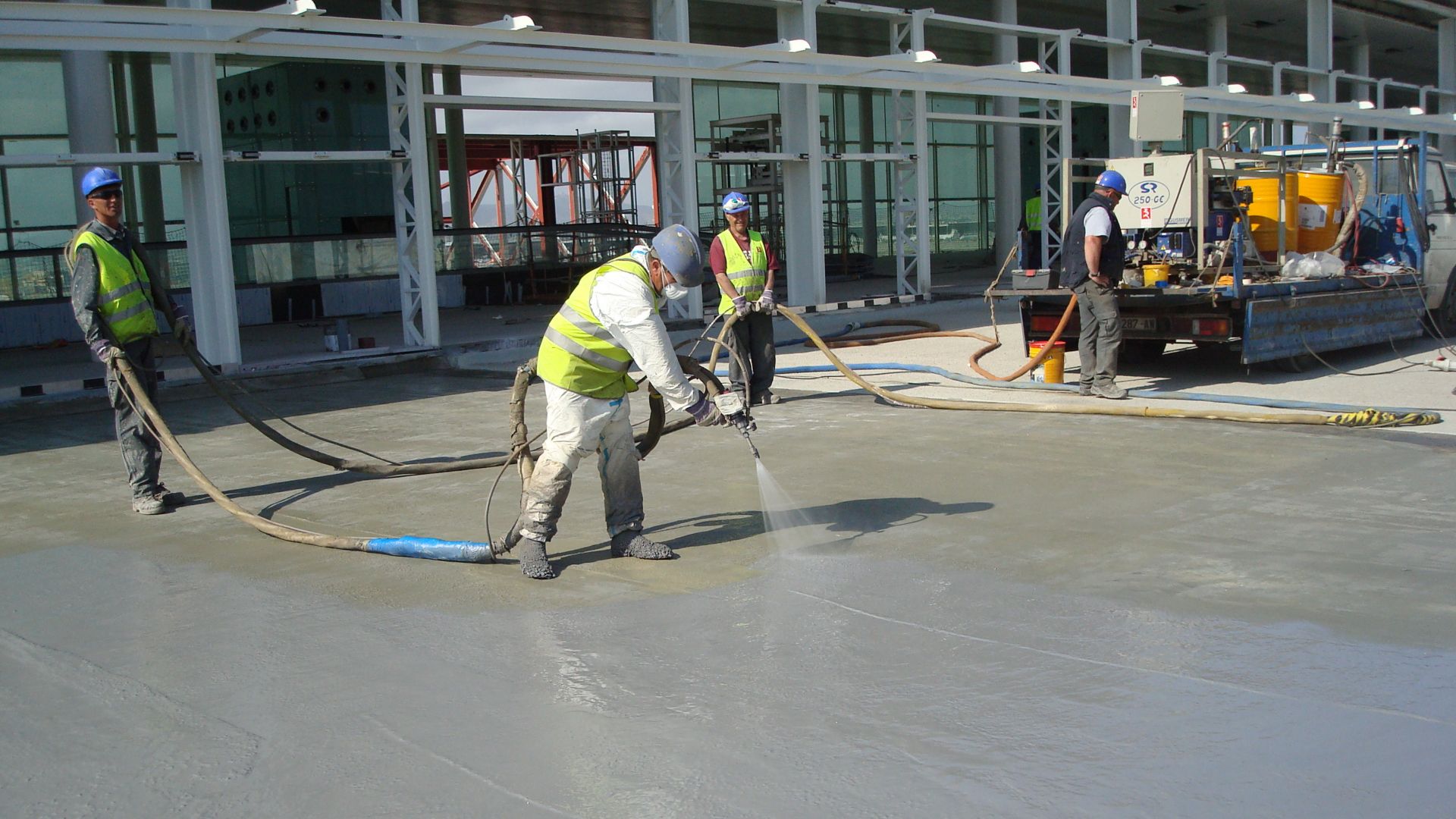 Workers applying waterproofing LAM system at the Barcelona El Prat Airport