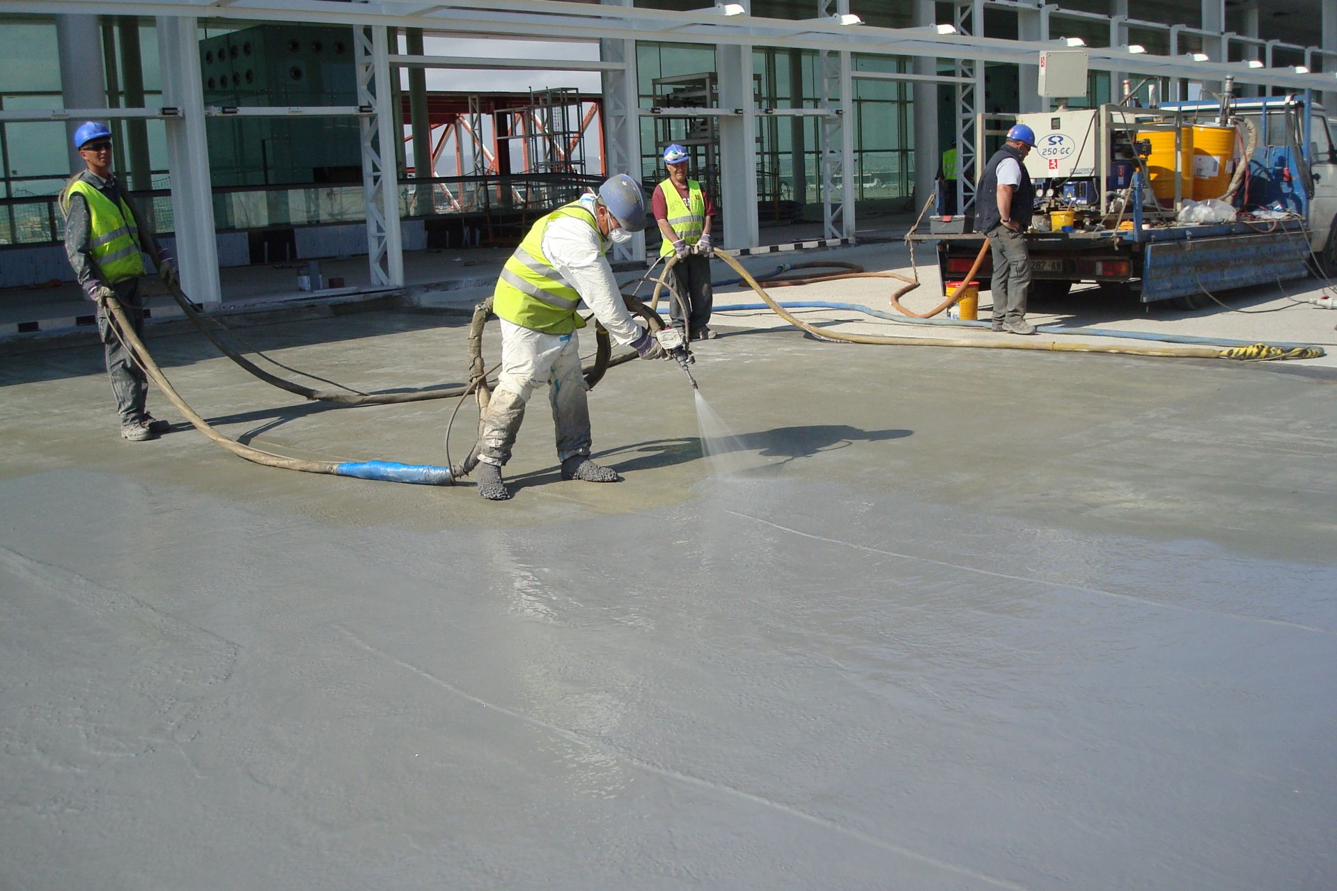 Workers applying waterproofing LAM system at the Barcelona El Prat Airport