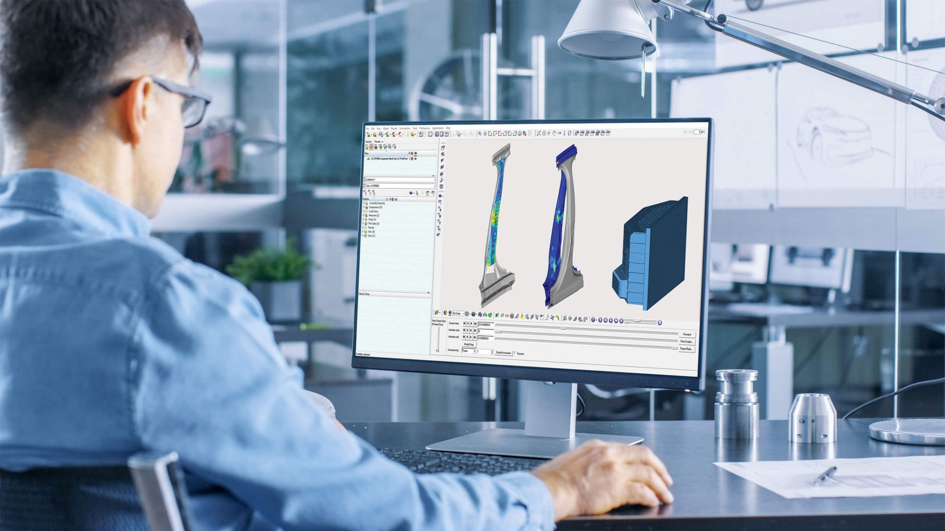 Automotive engineer sitting at desk reviewing Sika Structural solutions via CAD on computer screen