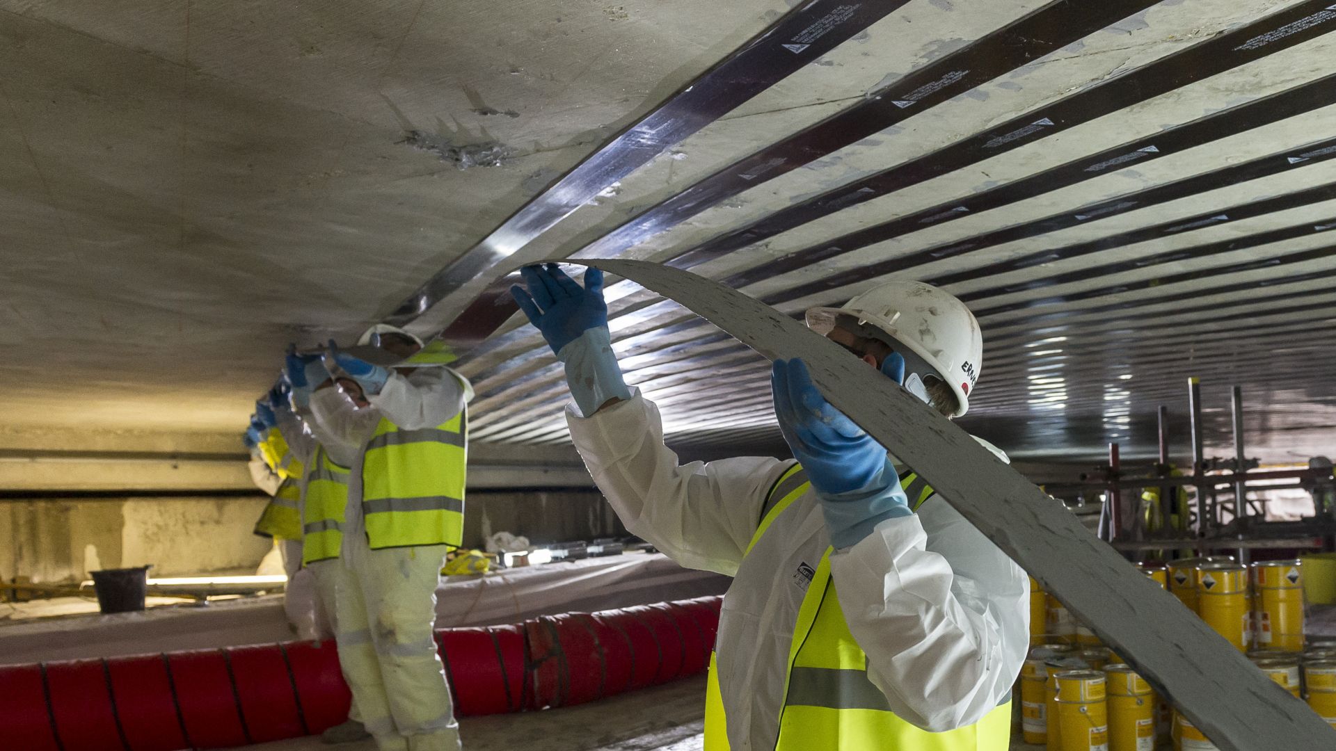 Men applying Sika CarboDur carbon fiber plates for structural strengthening