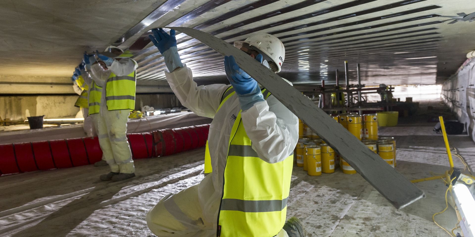 Men applying Sika CarboDur carbon fiber plates for structural strengthening