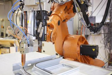 System engineering department testing robot equipment for adhesive application