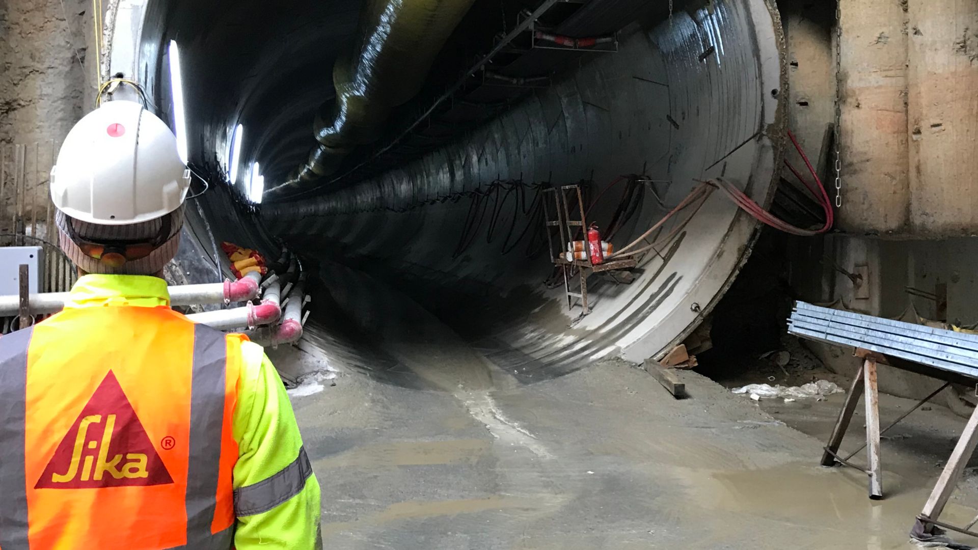 Sika engineer standing next to tunnel boring machine in tunnel construction