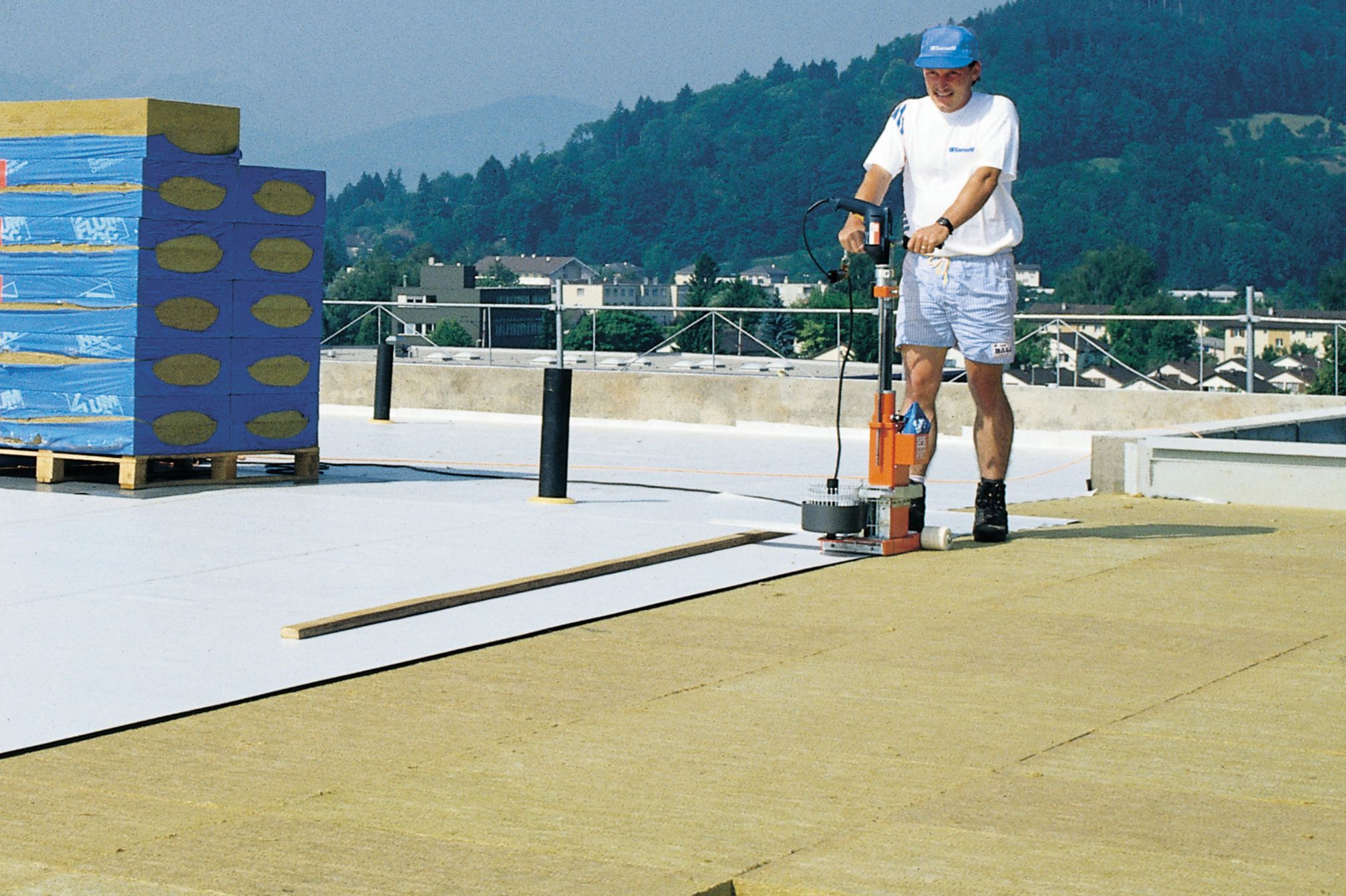 Man installing thermal insulation with a machine