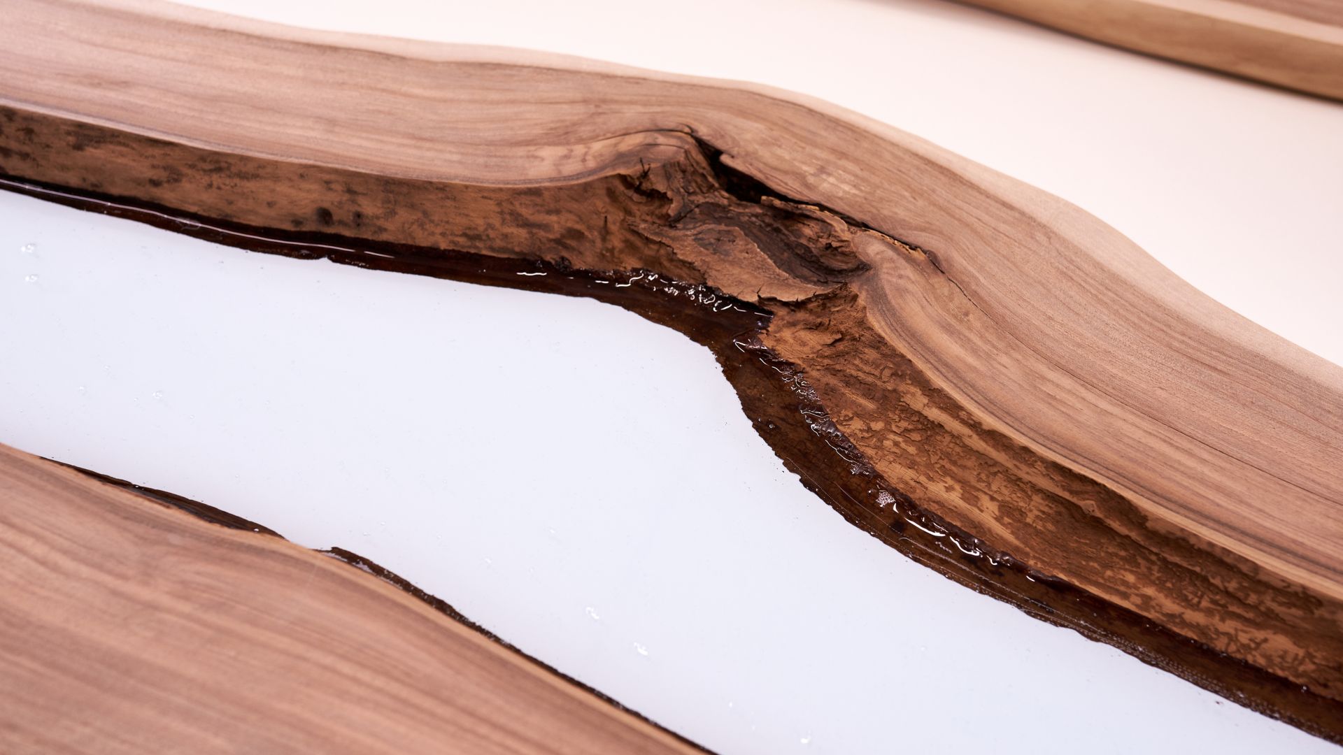 Process making of a craft resin and wood table. Liquid epoxy is poured into a mold with wooden blanks. closeup