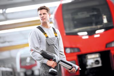 拿着在火车厂的人强力分配器