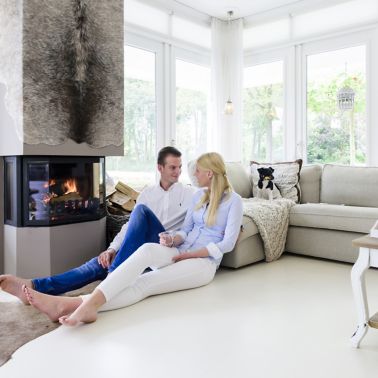 Sika ComfortFloor® white floor in fireplace living room with couple sitting on floor