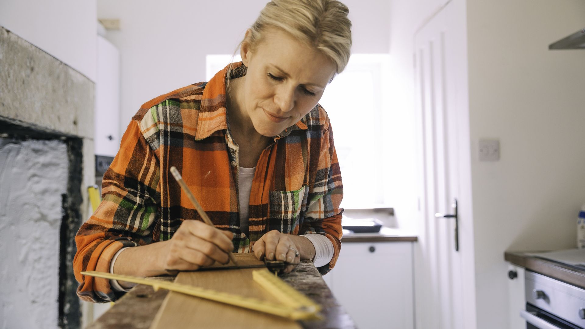 Woman measuring wood for DIY home improvement project